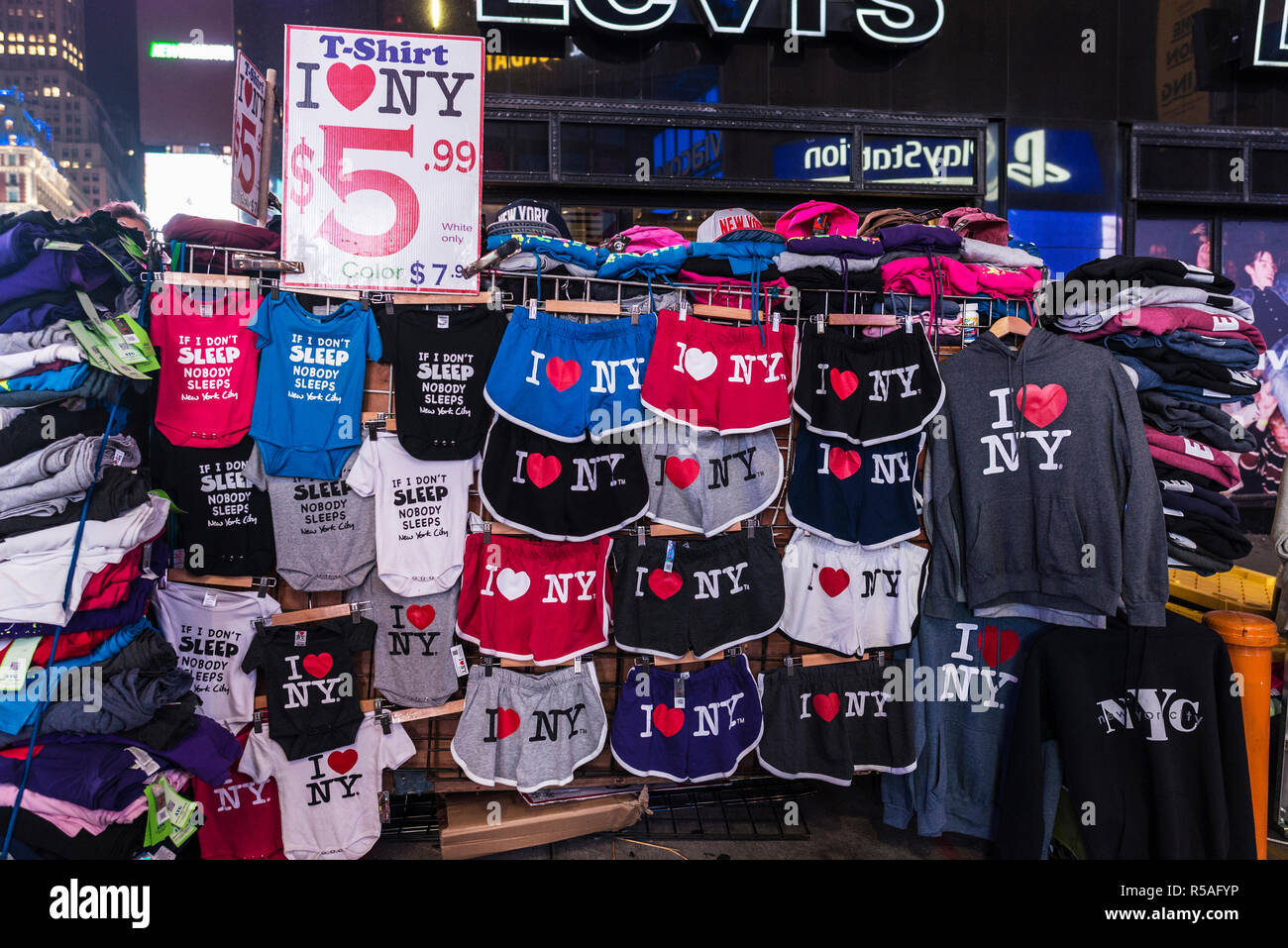New York City, USA - July 30, 2018: Souvenir shop with T-shirts with the logo of I love NY on Times Square at night with large advertising screens in  Stock Photo