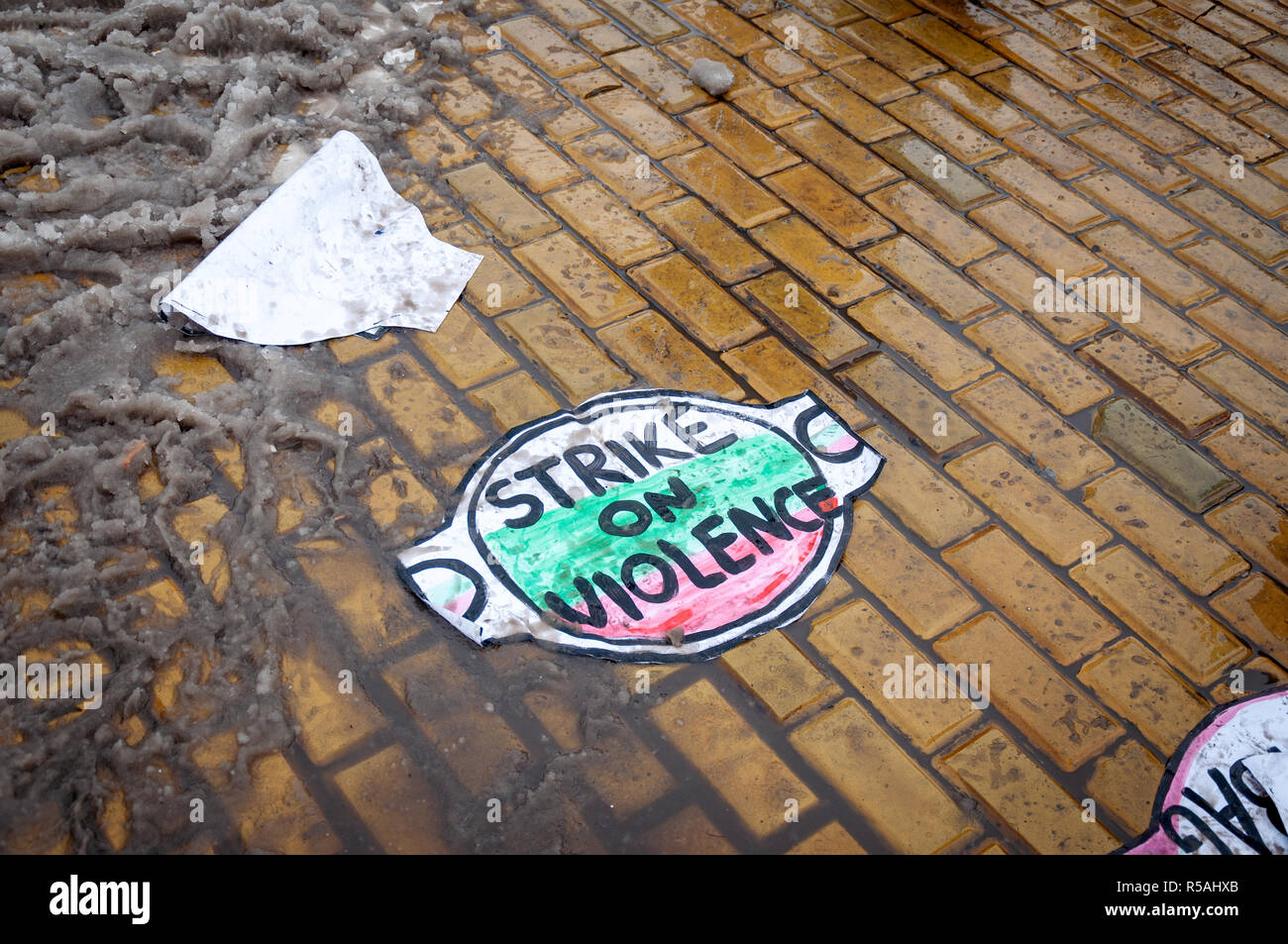 Placard against violence on the ground during one of the FEMEN activists protest. Bulgaria flag colors on placard. Stock Photo