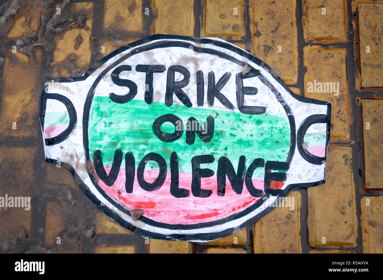 Placard against violence on the ground during one of the FEMEN activists protest Bulgarian National flag colors on placard. Stock Photo