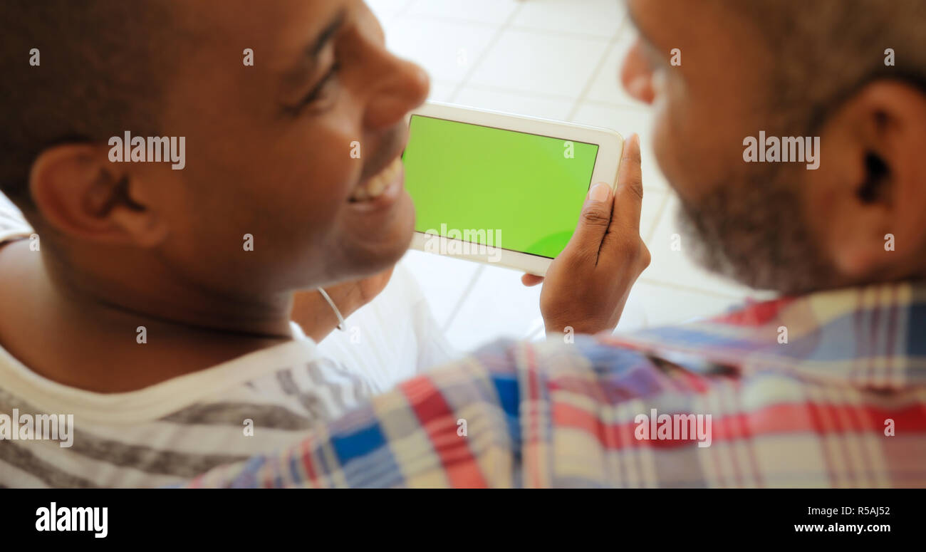 Green Screen Tablet Monitor With Gay Couple Using Internet Stock Photo