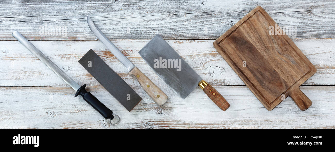 Cooking knives with wet stone and steel for sharpening on white rustic