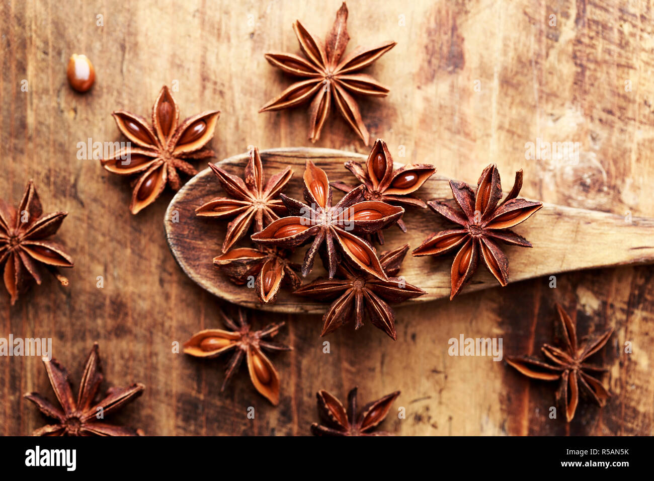 Anise stars on wood spoon close-up. Anason, anise star over wood background. Stock Photo