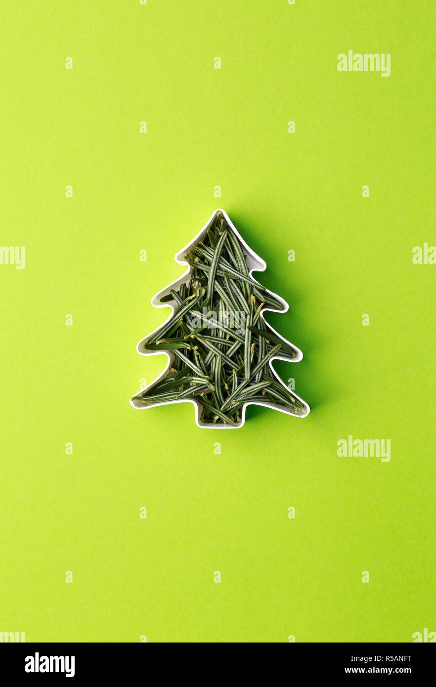 Christmas tree made of fir branches in the shape of a cake. Christmas tree concept over green background. Stock Photo