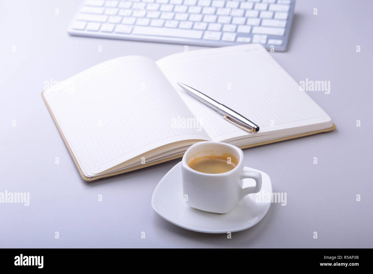 office table with notebook, ballpoint pen, computer keyboard, cup of coffee, tablet pc. copy space Stock Photo