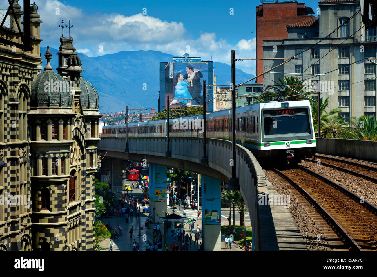 Medellin, Colombia, Elevated Metro Pulls Into Parque Berrio Station In Front Of The Palace Of Culture, A Painting By Artist Fernando Botero Adorns A Building, Andes Mountains, Aburra Valley, Antioquia Stock Photo