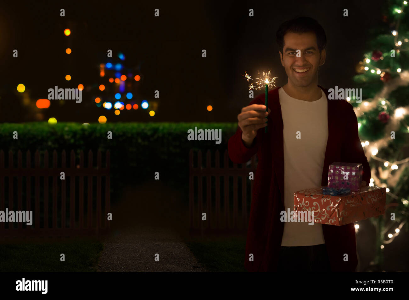 Man holding a present and a star shaped sparkler Stock Photo