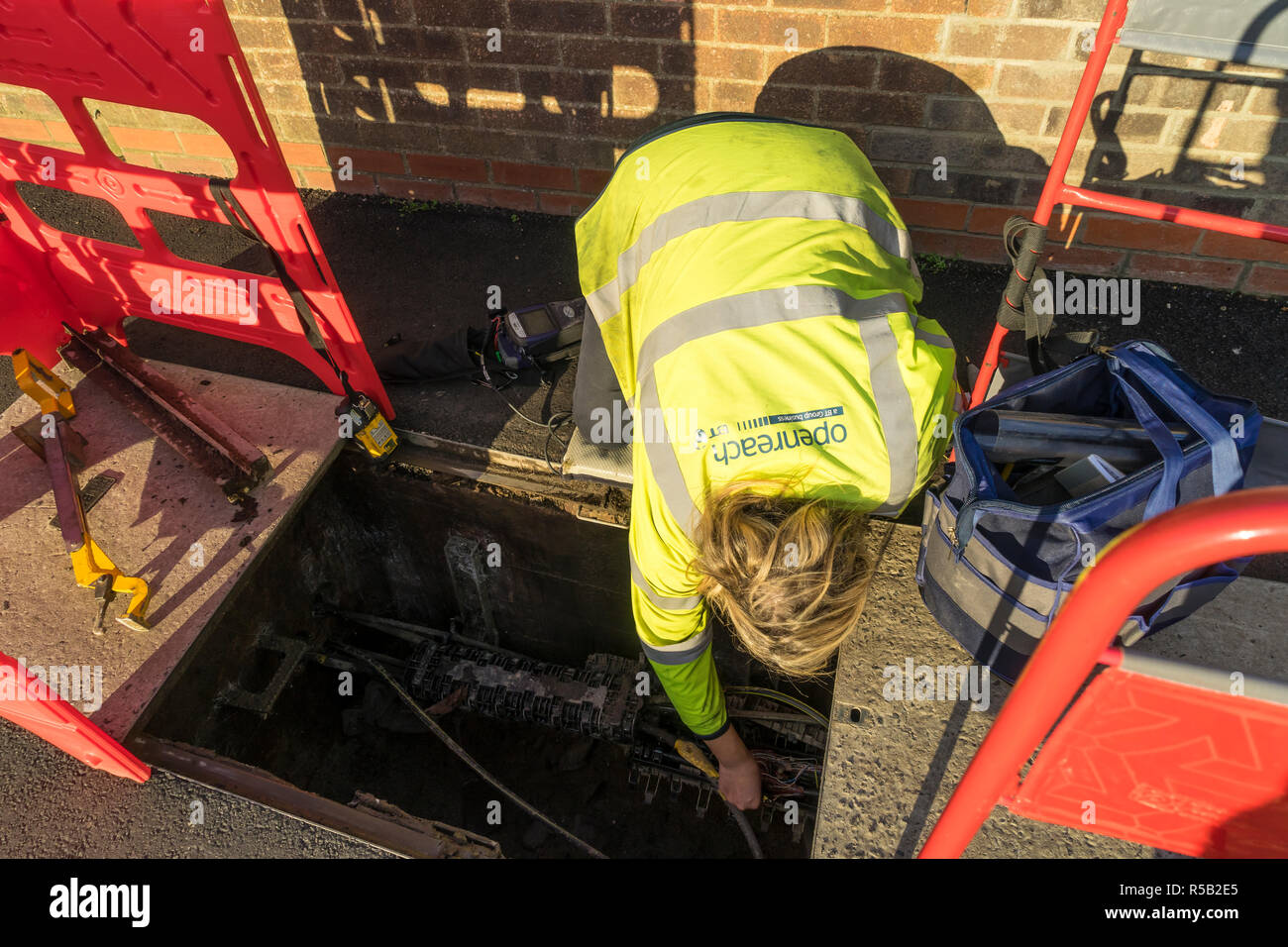 Openreach female operative fault-finding in underground junction box Stock Photo