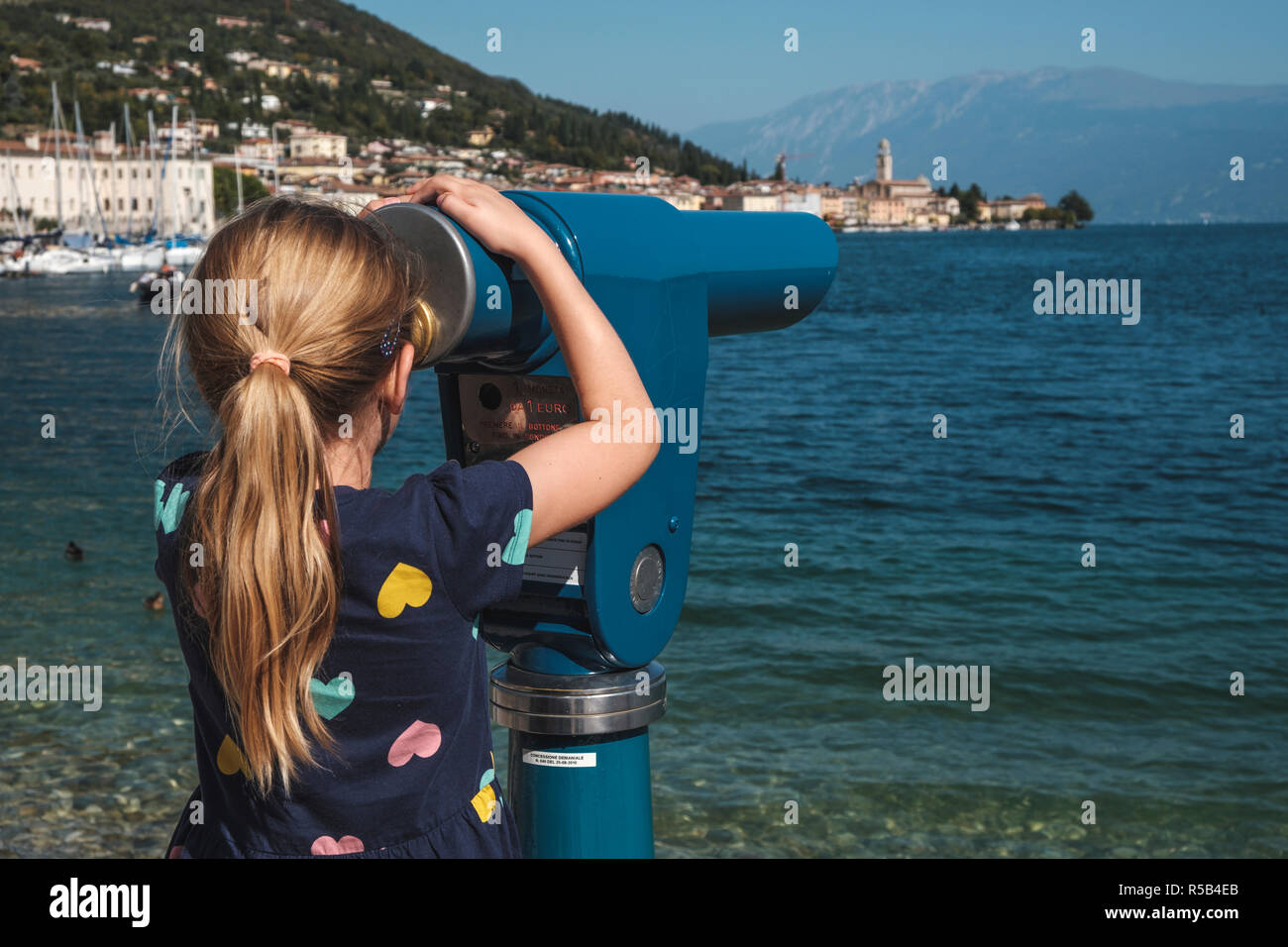 Little girl at the telescope, Salò, Lake Garda, Brescia province, Lombardy, Italy Stock Photo