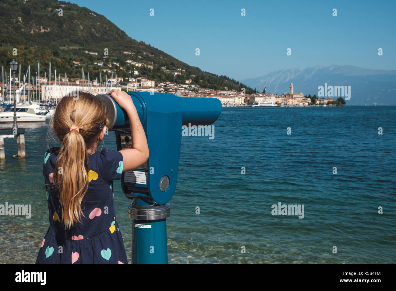Little girl at the telescope, Salò, Lake Garda, Brescia province, Lombardy, Italy Stock Photo