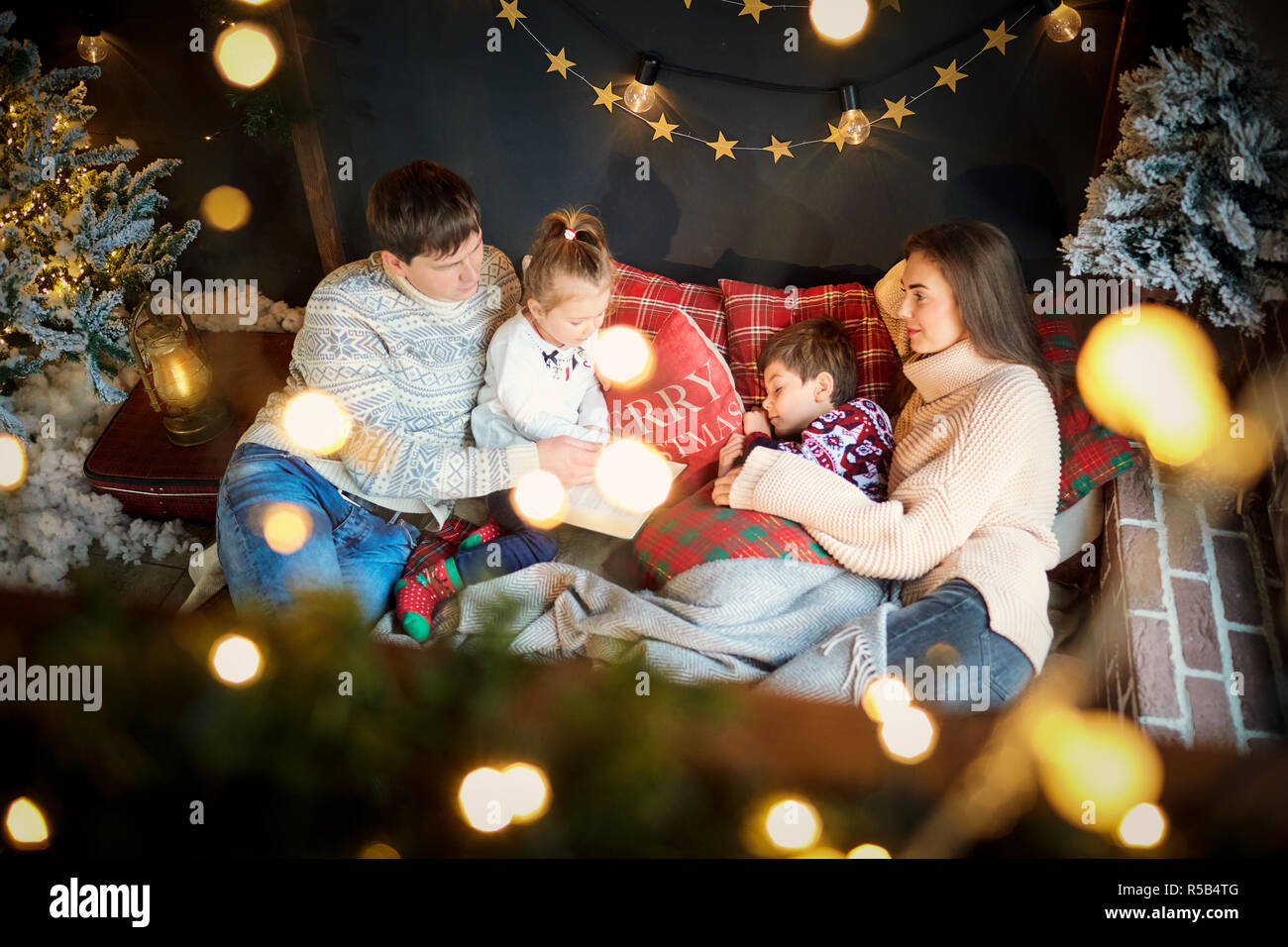 Mother and father with children playing at home on Christmas Day Stock Photo