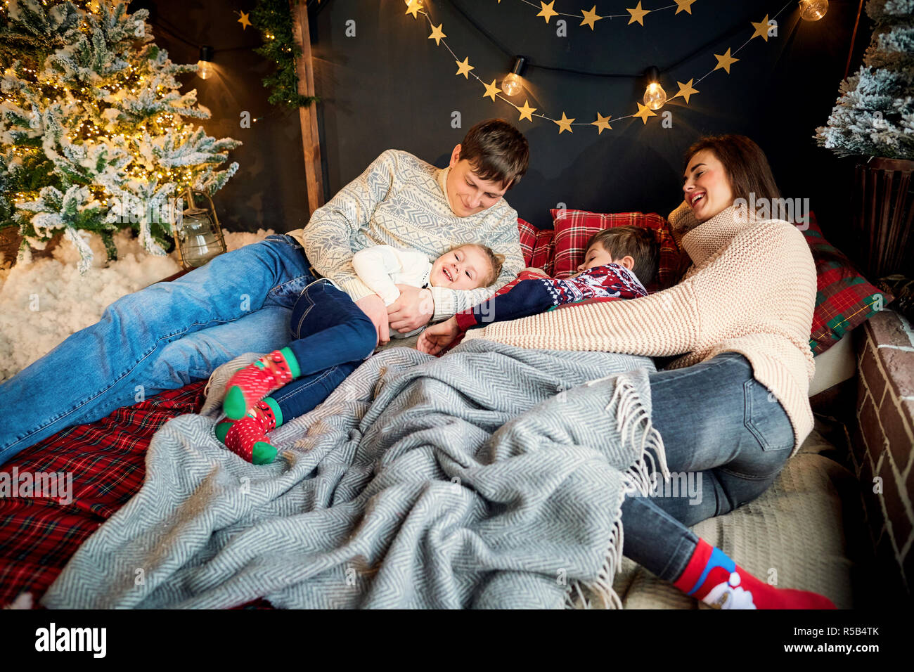 Mother and father with children playing at home on Christmas Day Stock Photo