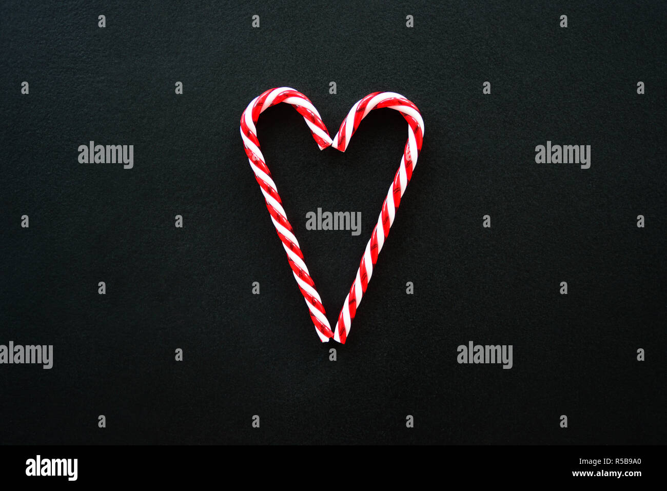Heart made from candy canes on blackboard Stock Photo
