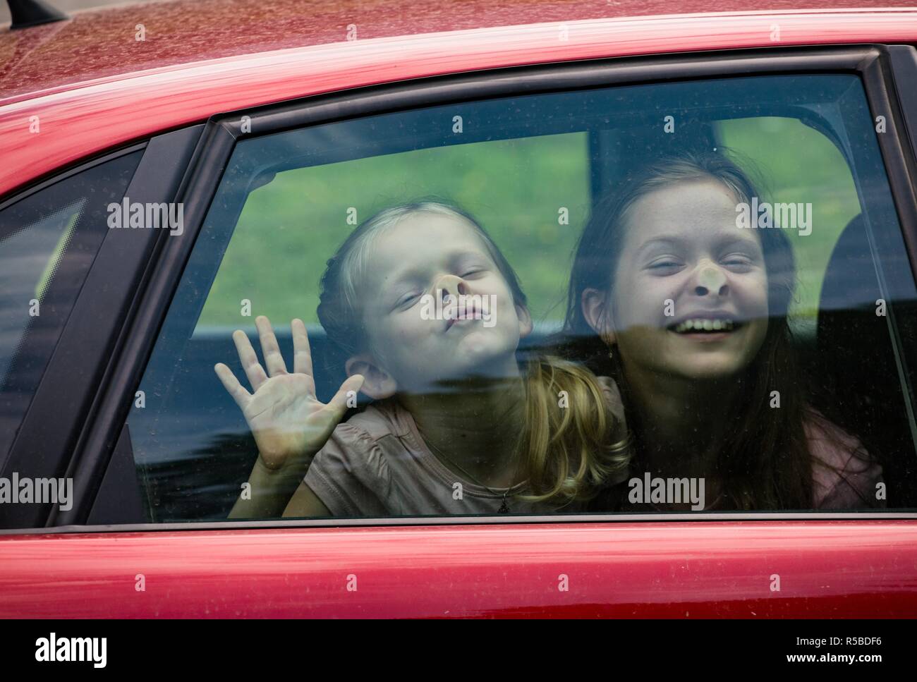 children making funny faces sitting at the car Stock Photo Alamy