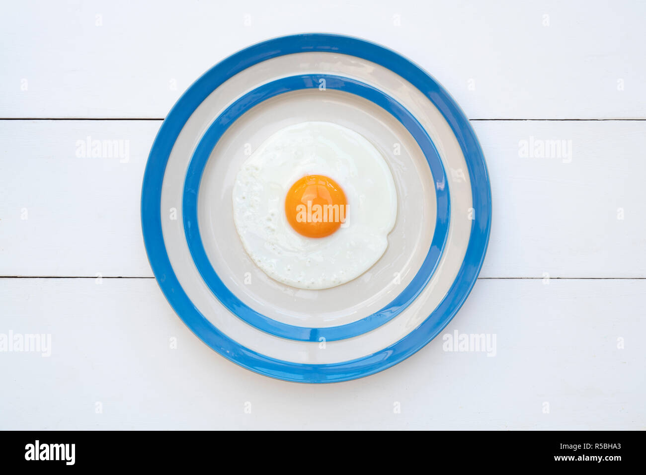 Fried Hens Egg on a cornishware plate Stock Photo