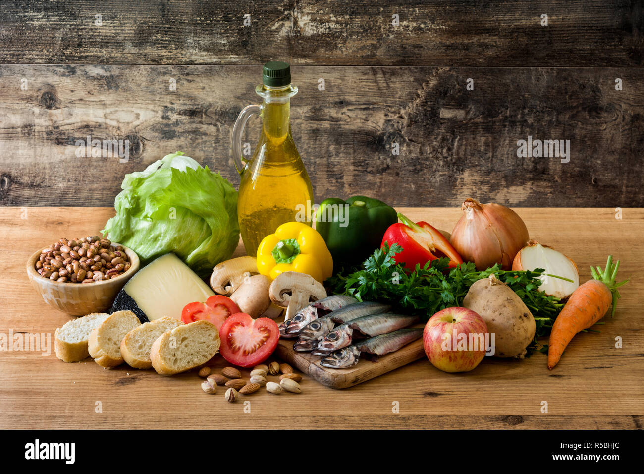 Healthy eating. Mediterranean diet. Fruit,vegetables, grain, nuts olive oil and fish on wooden table Stock Photo