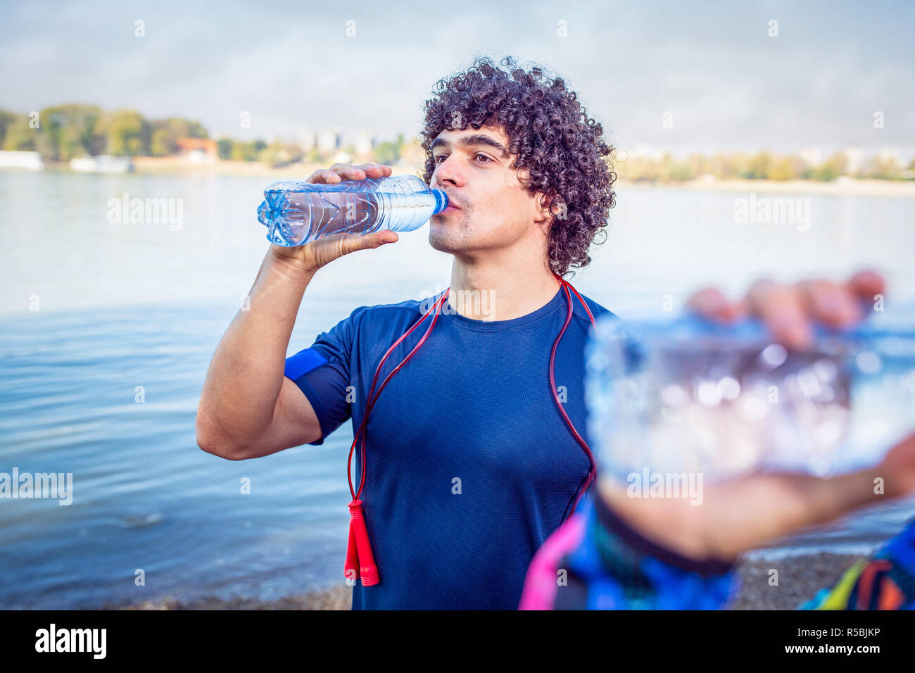 Resting After WorkoutMan drinks water to replenish energy Stock Photo