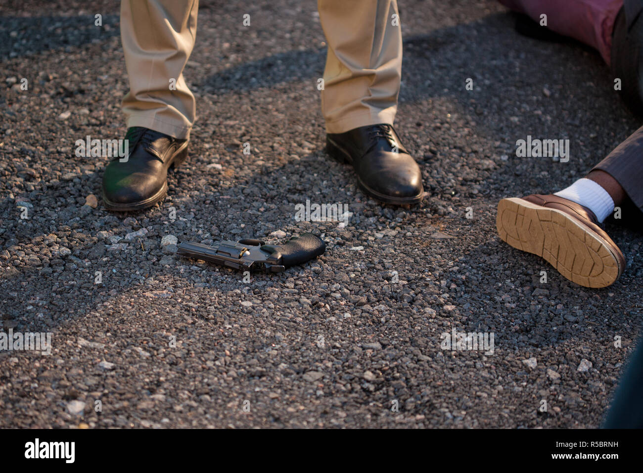 Detective at the crime scene. A man stands over the victim's body. Crime, murder outdoors Stock Photo