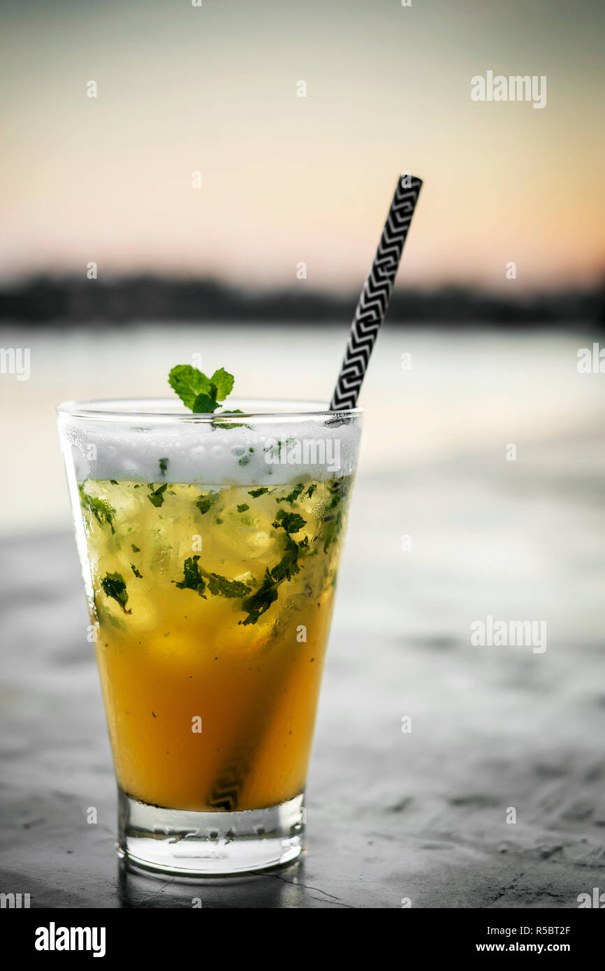 passion fruit mojito mixed cocktail drink with zesty egg white foam in riverside bar of