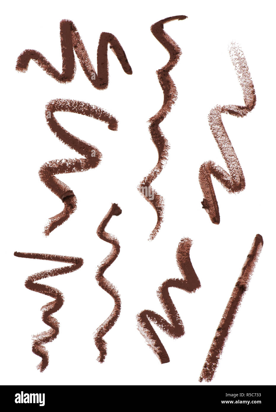 A still life cut out product image of a series of squiggles, lines or zig zags of brown makeup pencil on a white background Stock Photo