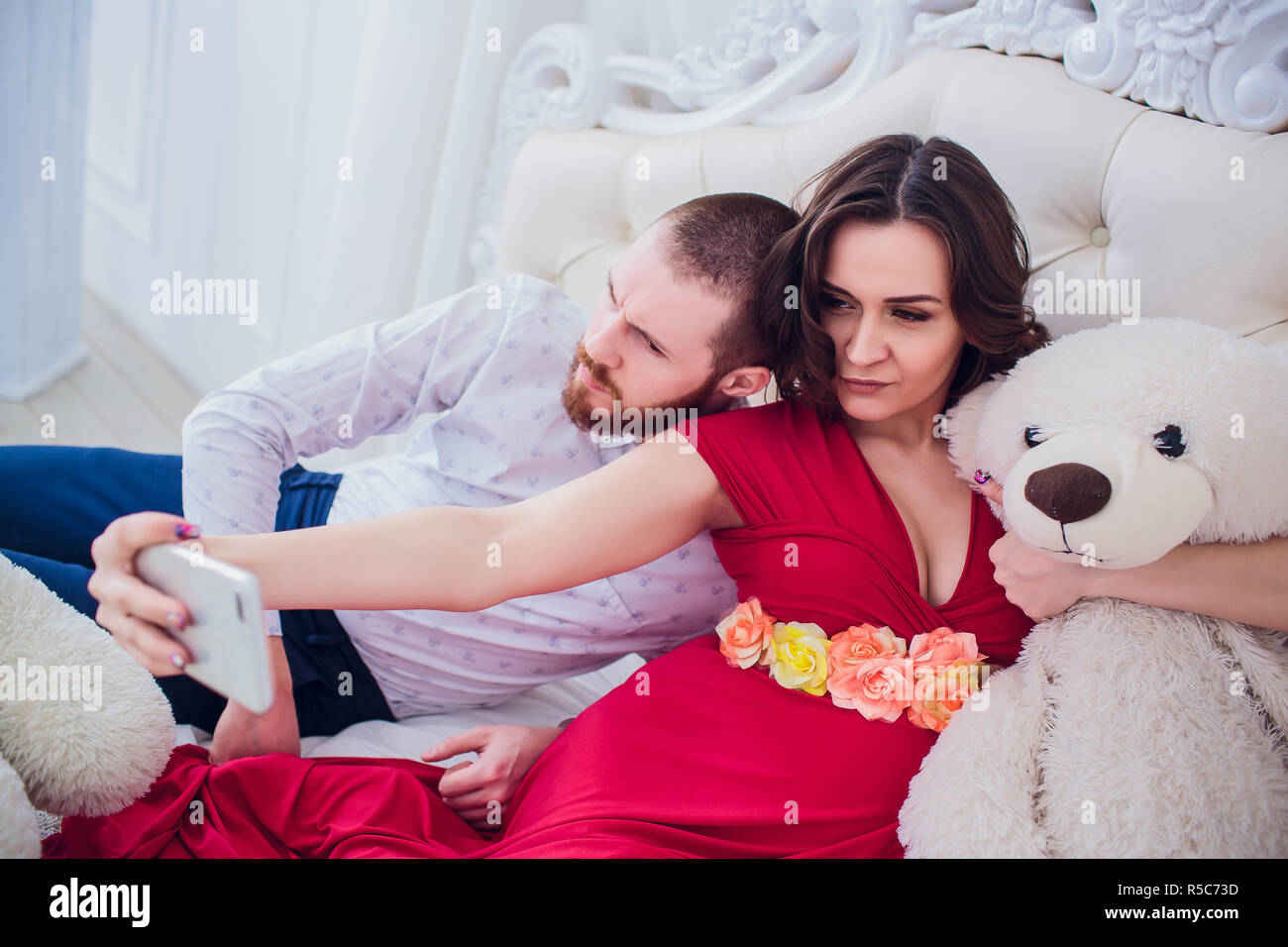 a-husband-and-a-pregnant-wife-make-selfie-sitting-on-the-couch-they