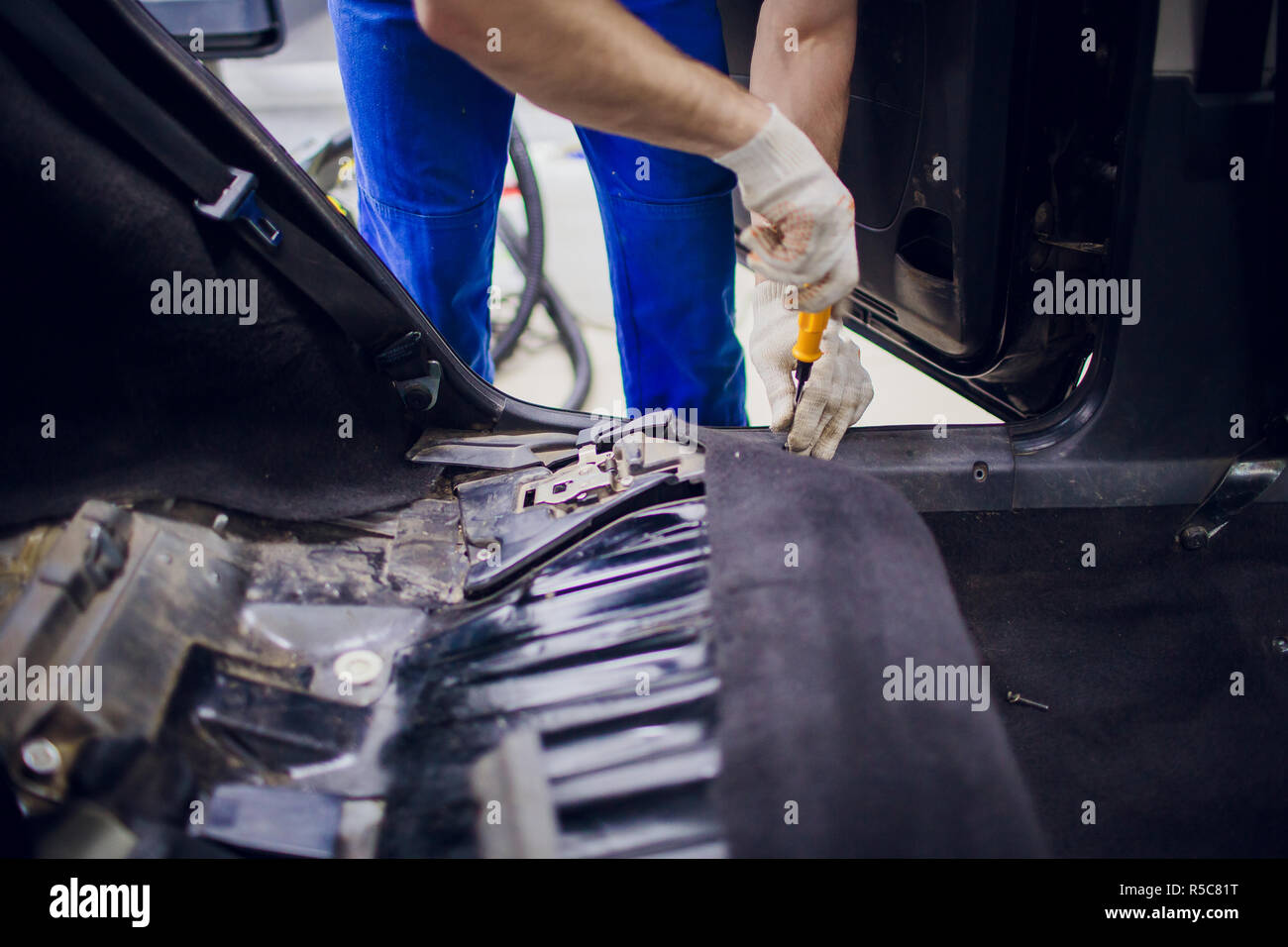 dismantling of the floor in the car mechanic male man removes the