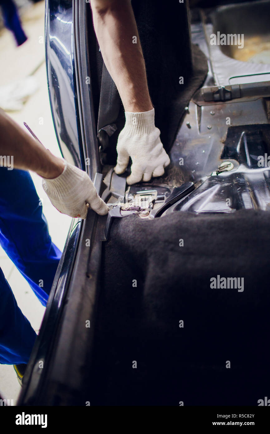 dismantling of the floor in the car mechanic male man removes the