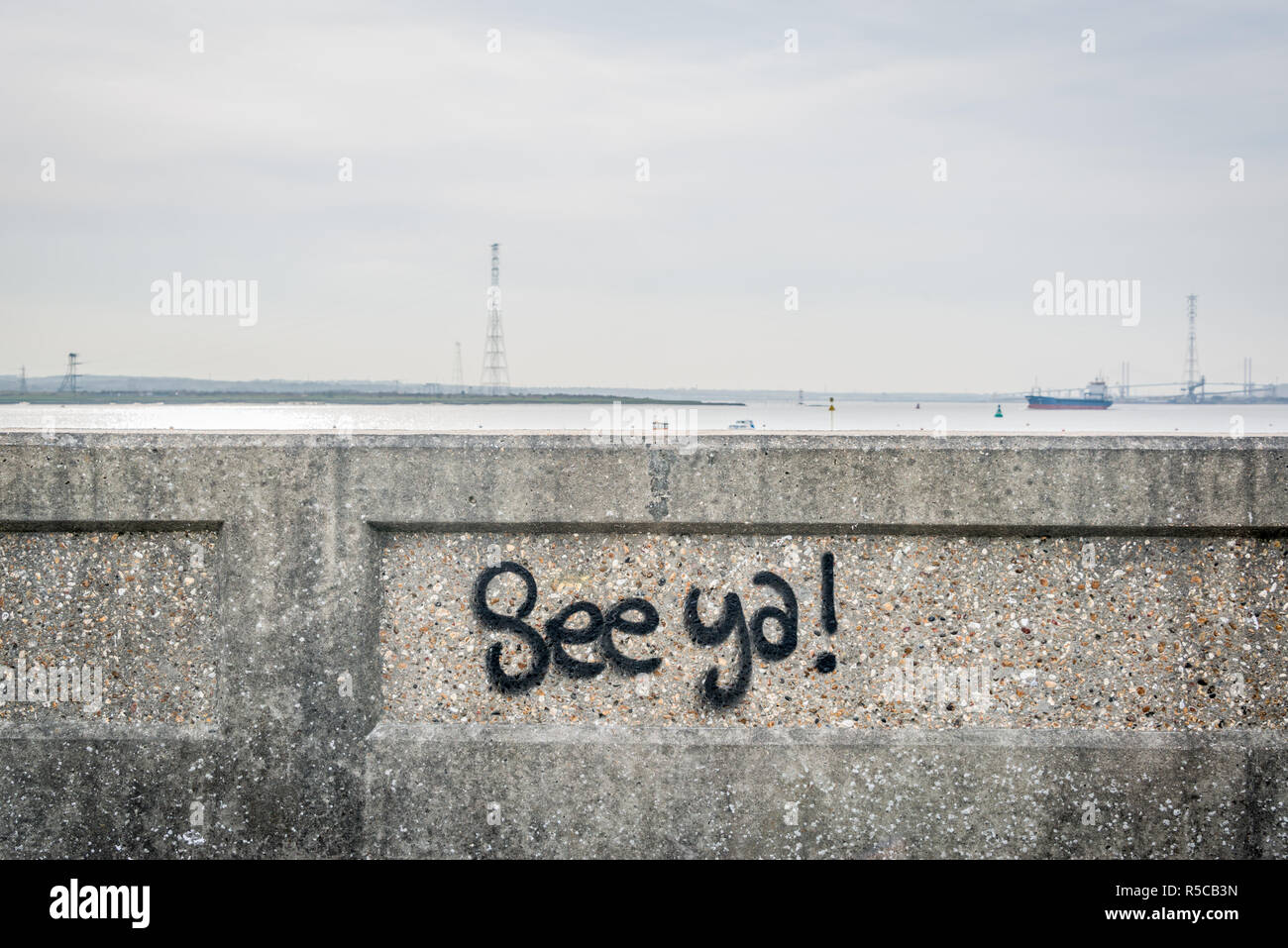 'See ya' grafitti on a concrete wall by the Thames estuary at Tilbury, Essex, UK Stock Photo