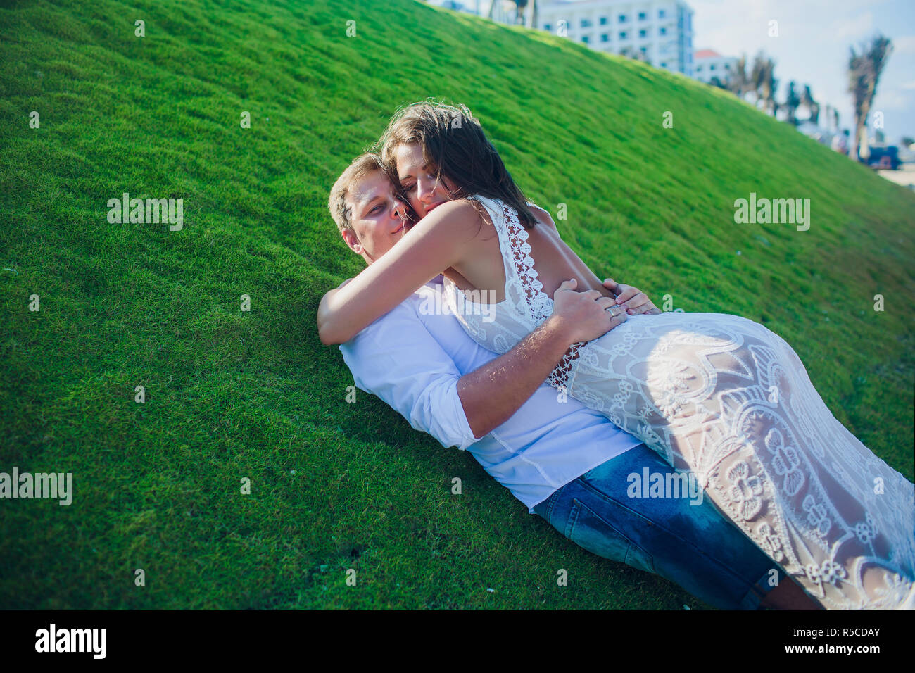 couple laying on the grass green summer Stock Photo - Alamy