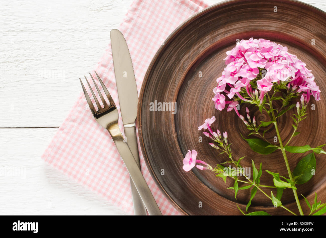 Spring table settings with fresh flower, napkin and silverware. Holidays background. Selective Focus. Stock Photo