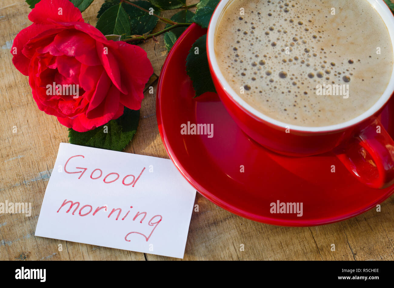 Coffee cup with red rose flower and notes good morning on wooden ...