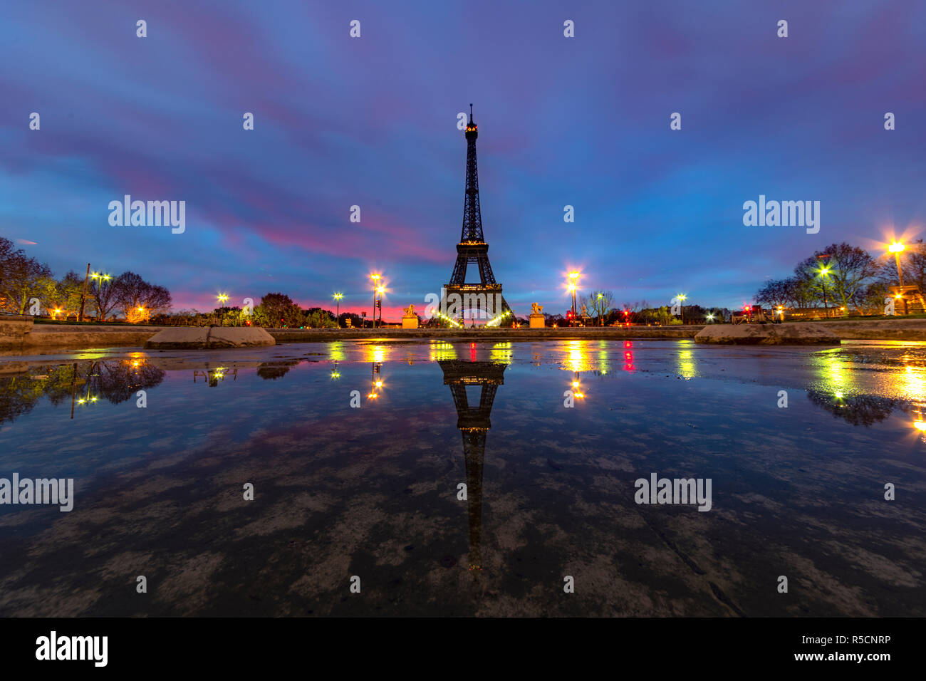 Sunrise on the Eiffel tower reflection on the Trocadero fountain water in Paris, one of the most visited building by the tourists Stock Photo