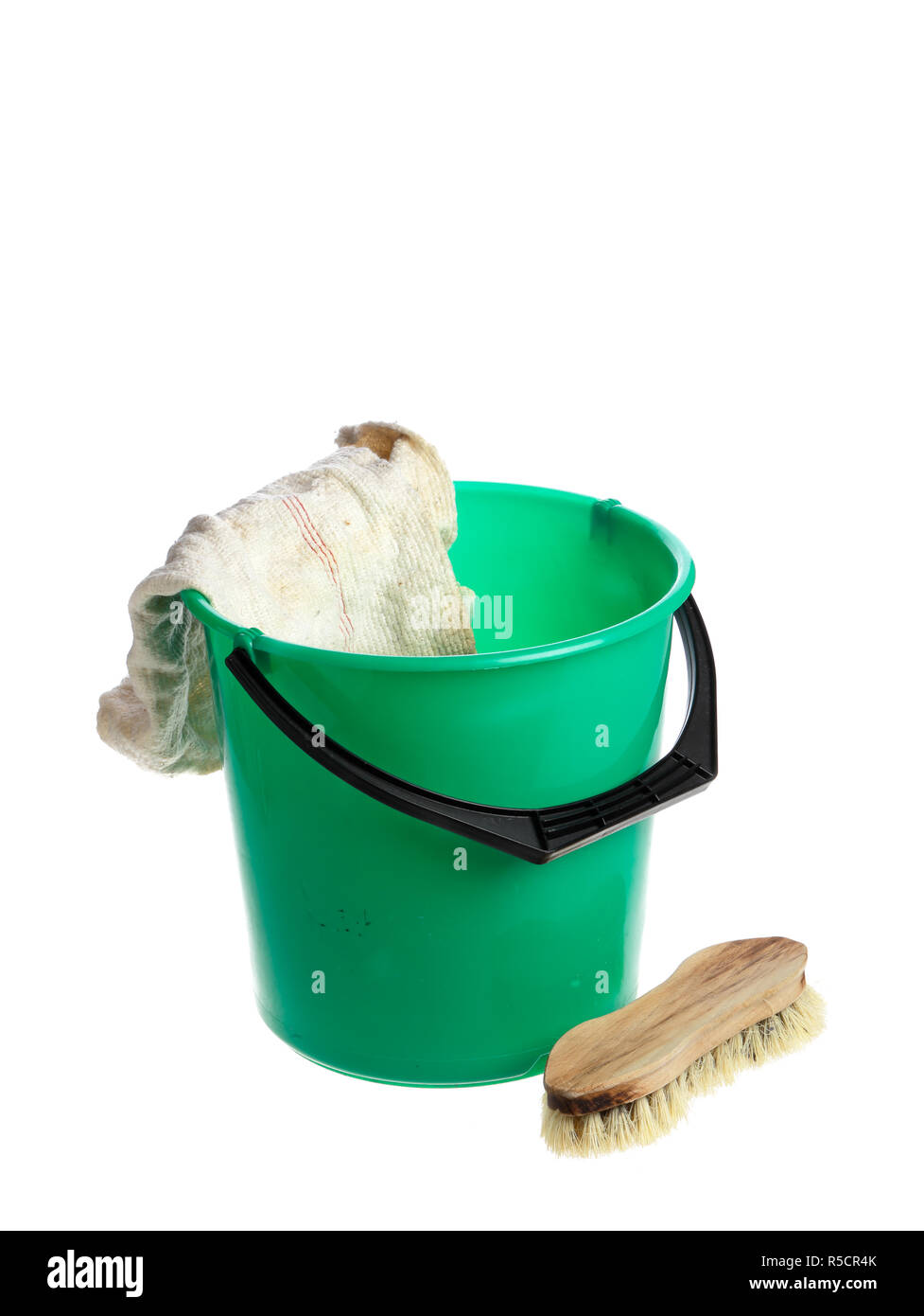 Green plastic bucket with a floorcloth hanging on its rim with a scrub brush near by isolated on white background. Stock Photo