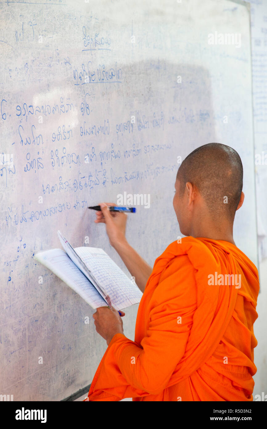 Laos, Luang Prabang, Monk Writing on Classroom Blackboard Stock Photo