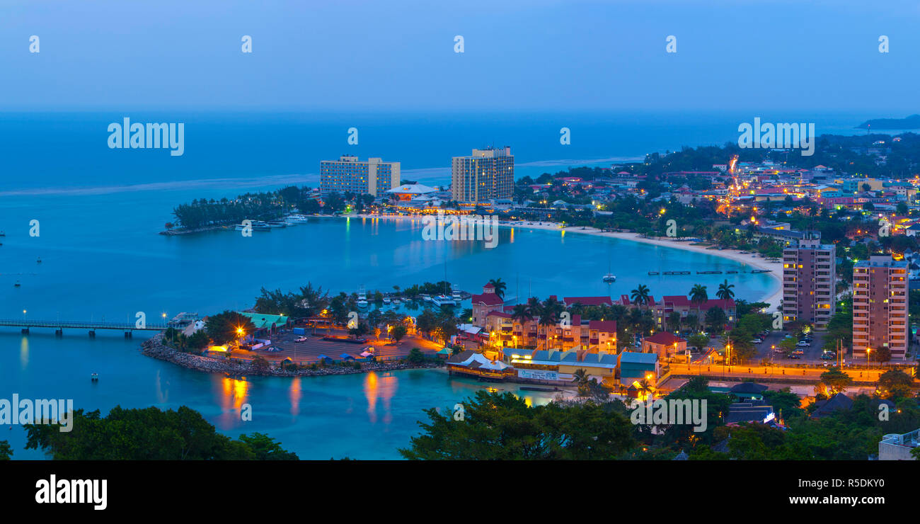 Elevated view over city & coastline illuminated at dusk, Ocho Rios, St