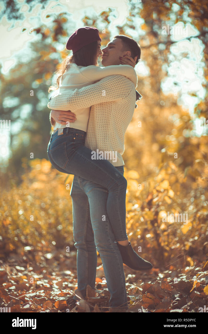 Sweet couple is in the park, hugging and looking very happy ...