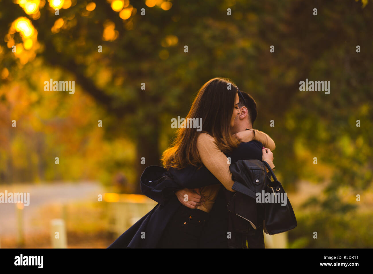 Young couple hugging and kissing at the park Stock Photo - Alamy
