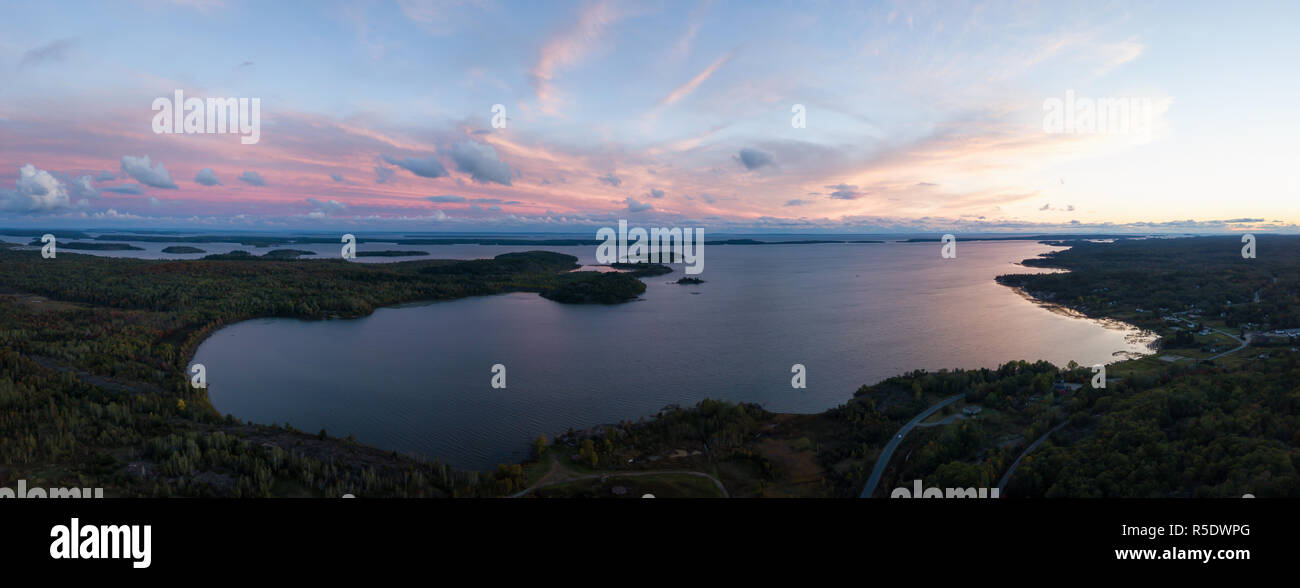 Aerial panoramic landscape view of a beautiful bay on the Great Lakes, Lake Huron, during a vibrant sunset. Located Northwest from Toronto, Ontario, C Stock Photo