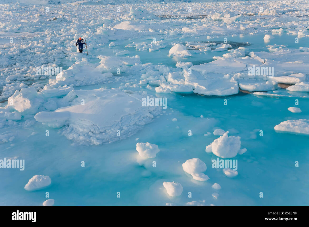 Seal hunter on sea ice, Tiniteqilaq, E. Greenland Stock Photo