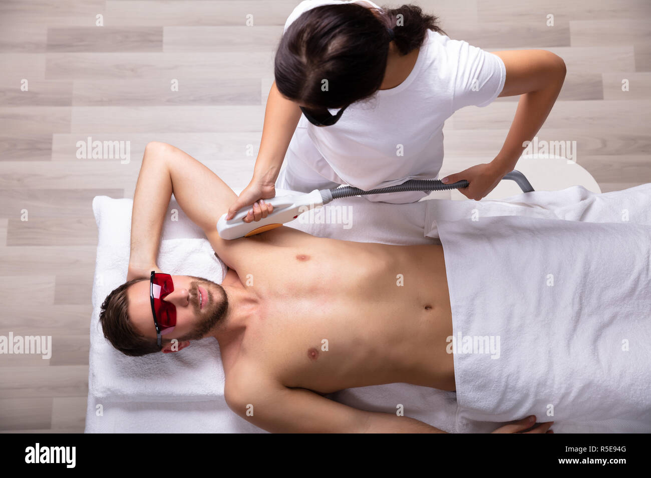 Close Up Of Smiling Young Man Having Underarm Laser Hair Removal