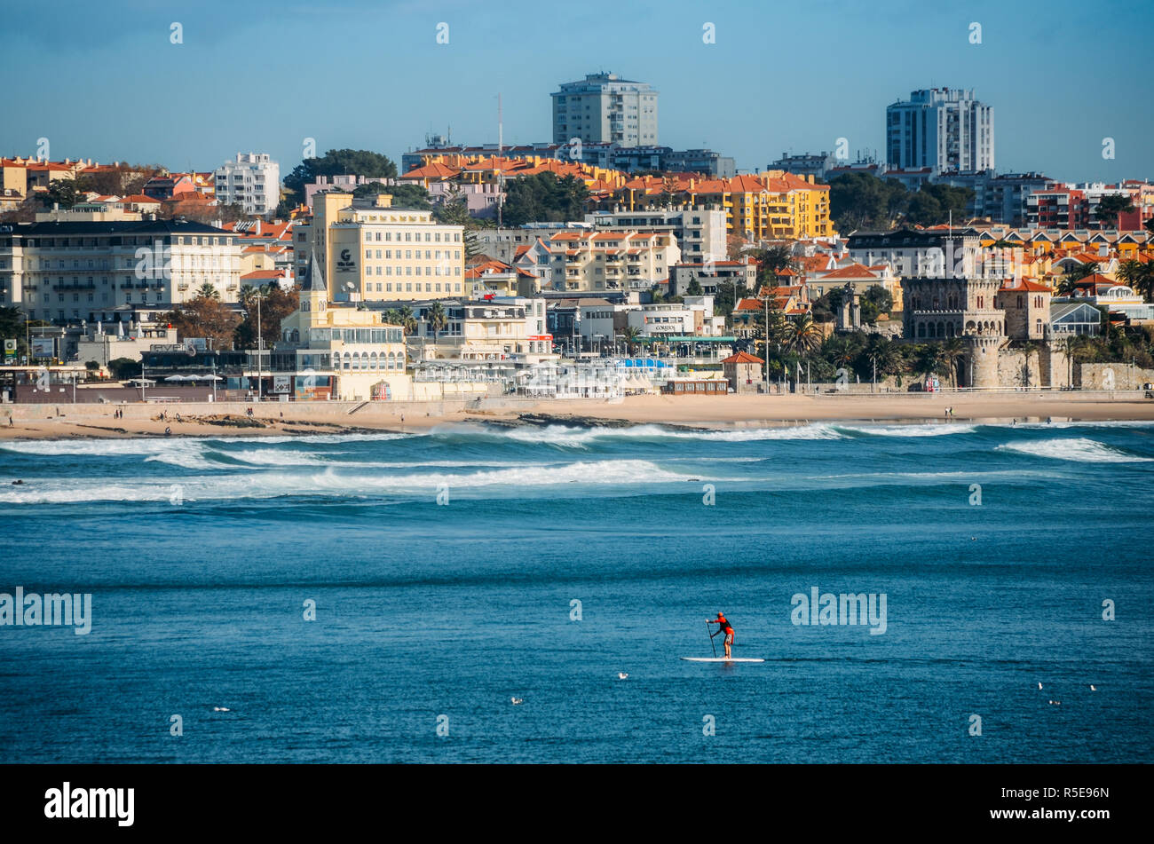 Estoril, Portugal - Nov 30, 2018: Man does stand up paddle overlooking the coast of Estoril near Lisbon, Portugal - with copy space Stock Photo