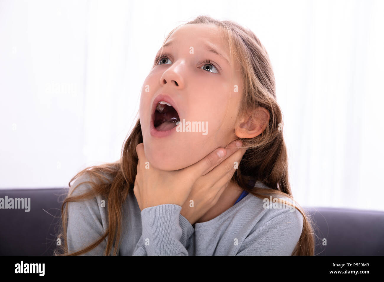 Portrait Of A Girl Unable To Breathe Pressing Her Neck Stock Photo