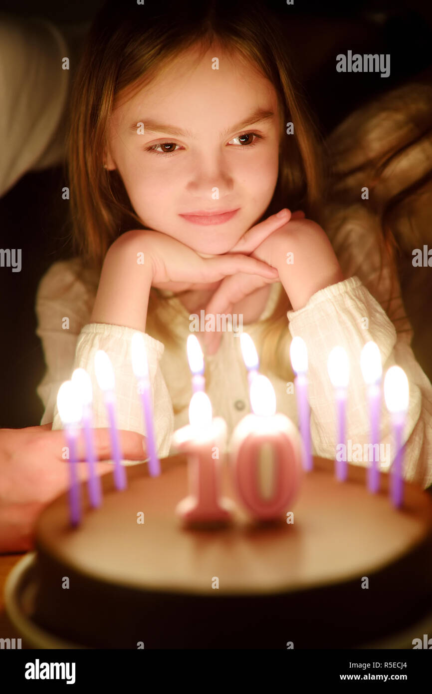 Cute ten years old girl making a wish before blowing candles on her