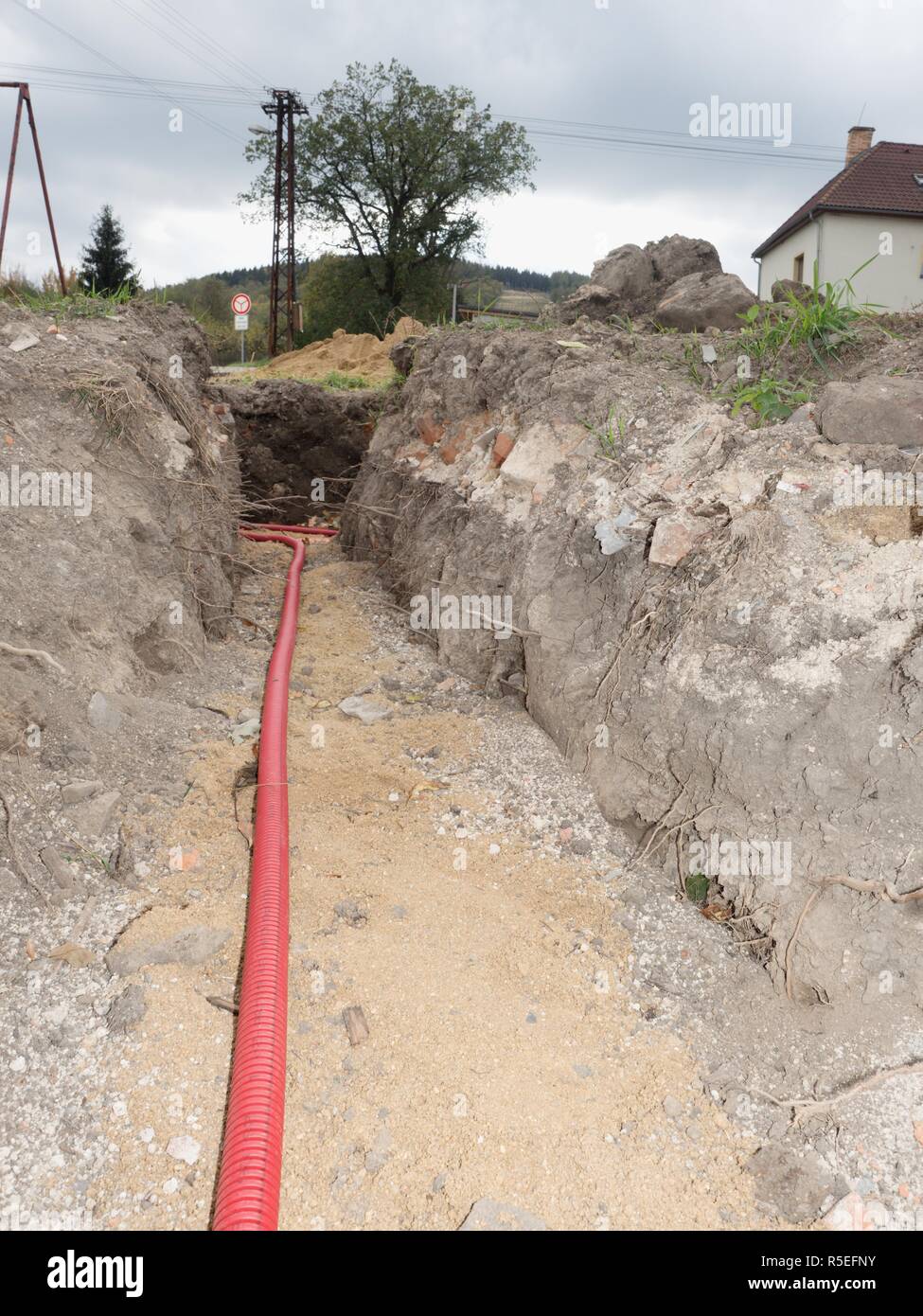 Safety tube with cables. Reconstruction site with trench for underground telephone optical lines