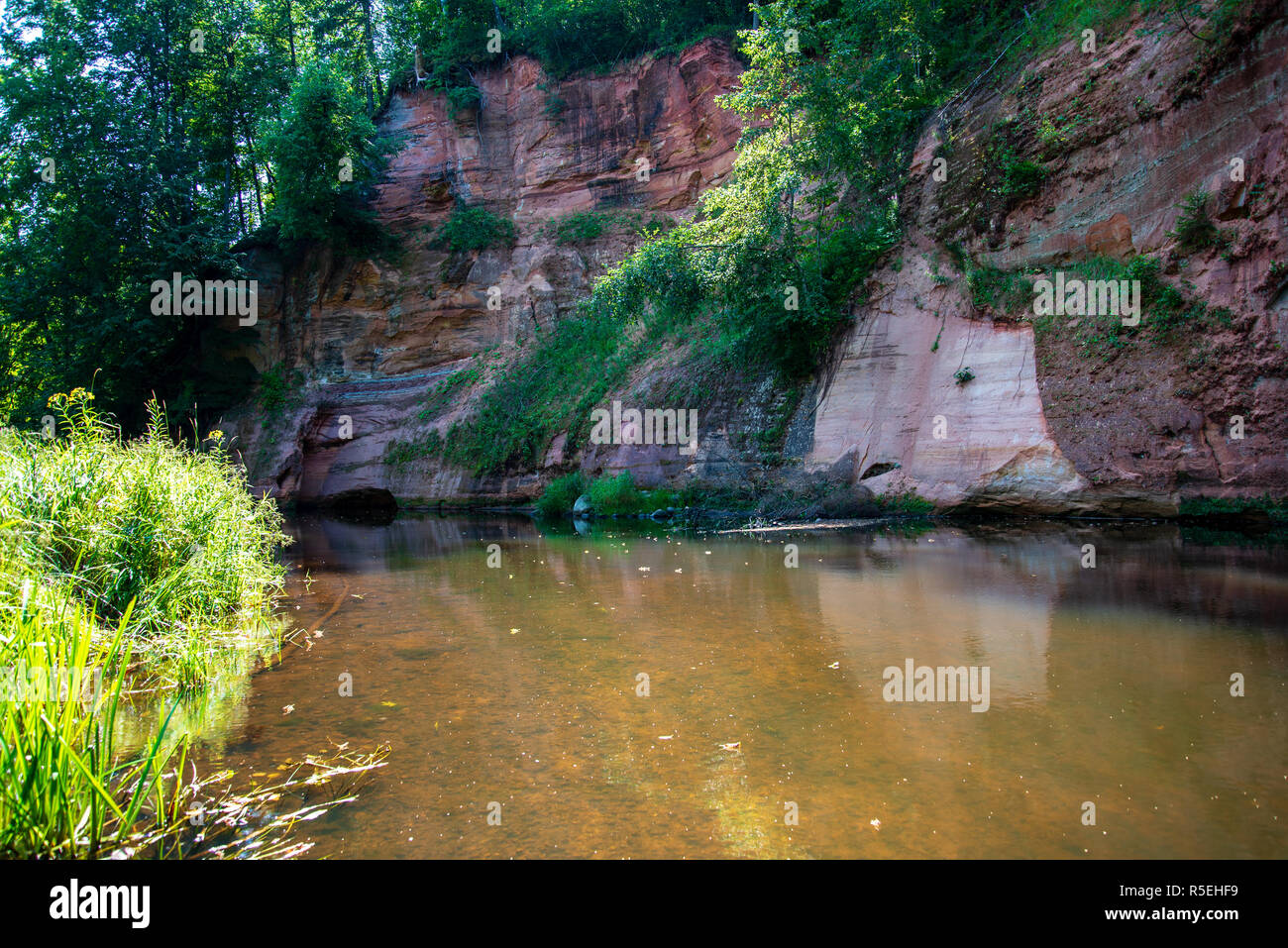 Brasla summer day on water in calm river enclosed in forests with sandstone ...