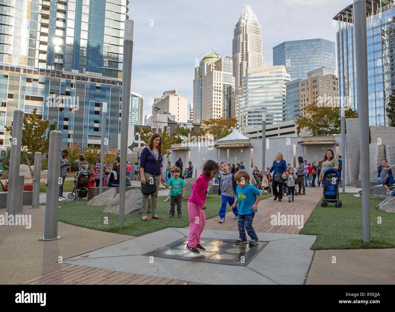 CHARLOTTE, NC - November 25, 2016:  Young families playing in Romare Bearden Park in uptown Charlotte, North Carolina. Stock Photo