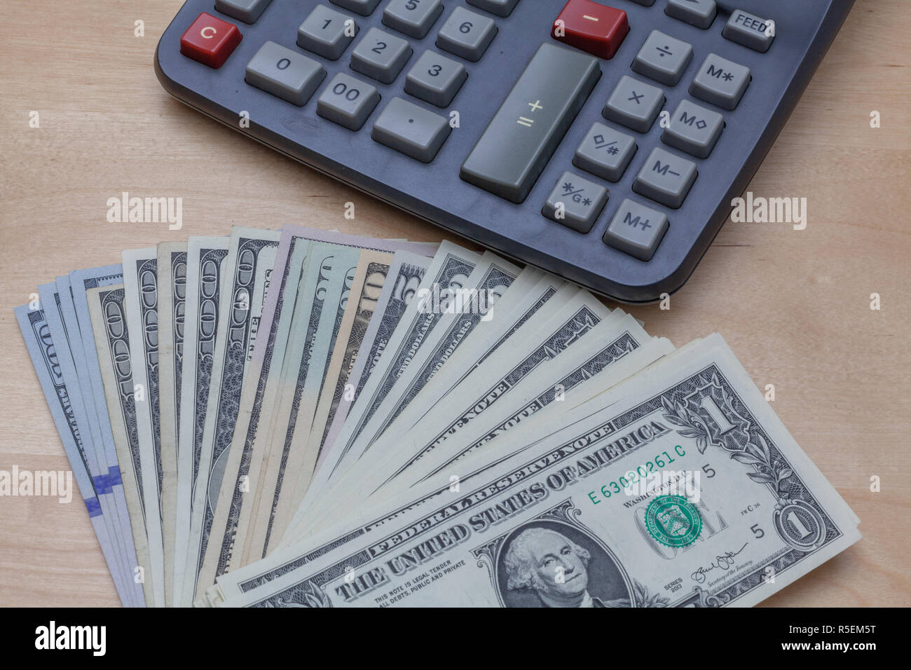 Counting Money with Calculator - US currency Stock Photo