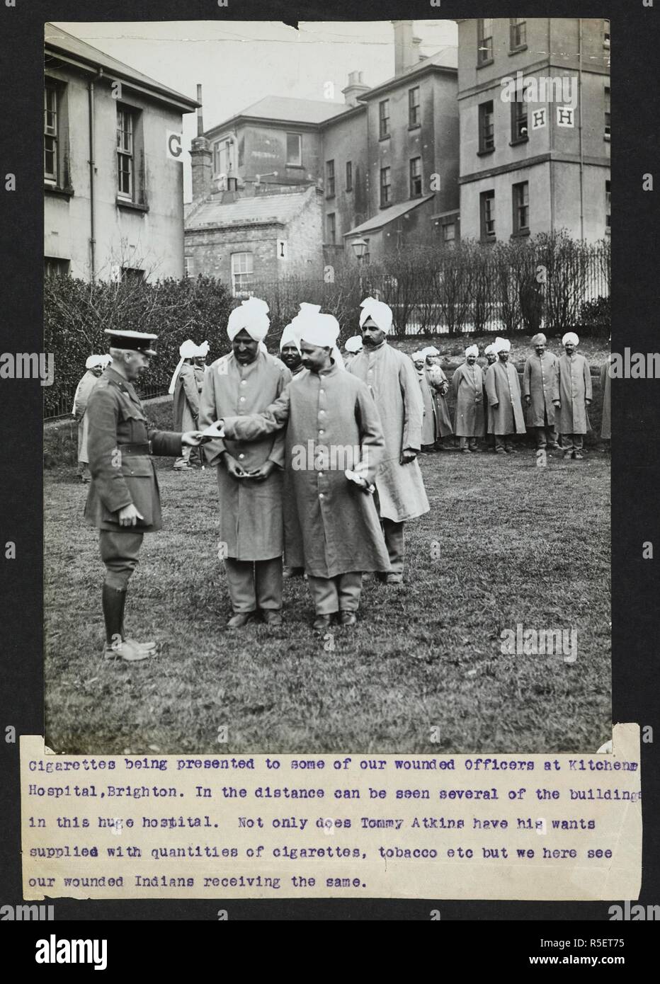 Cigarettes being presented to some of our wounded officers at Kitchener Hospital, Brighton. 'In the distance can be seen several of the buildings in this huge hospital. Not only does Tommy Atkins have his wants supplied with quantities of cigarettes, tobacco, etc but here we see our wounded Indians receiving the same'. Record of the Indian Army in Europe during the First World War. 20th century, 1915. Gelatin silver prints. Source: Photo 24/(12). Language: English. Author: Girdwood, H. D. Stock Photo
