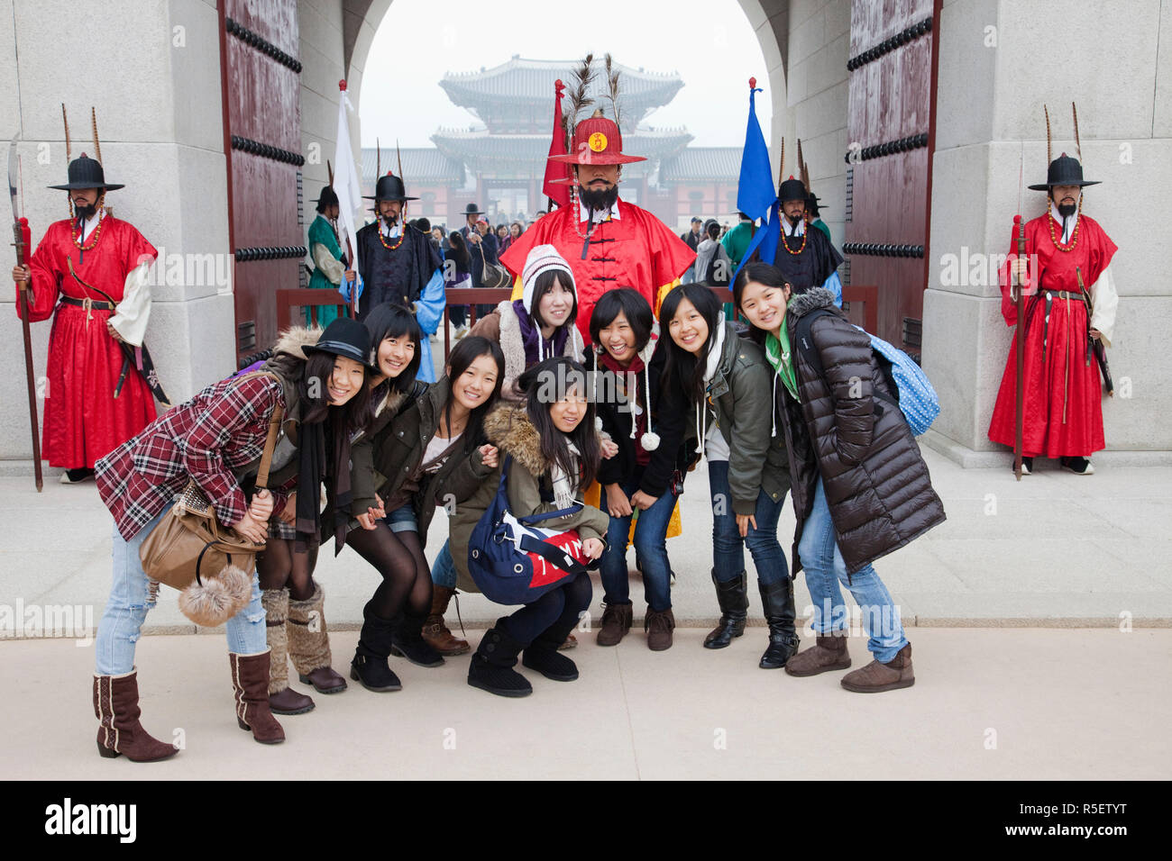 South Korea, Seoul, Gyeongbokgung Palace, Girls Posing with Ceremonial Guards Stock Photo