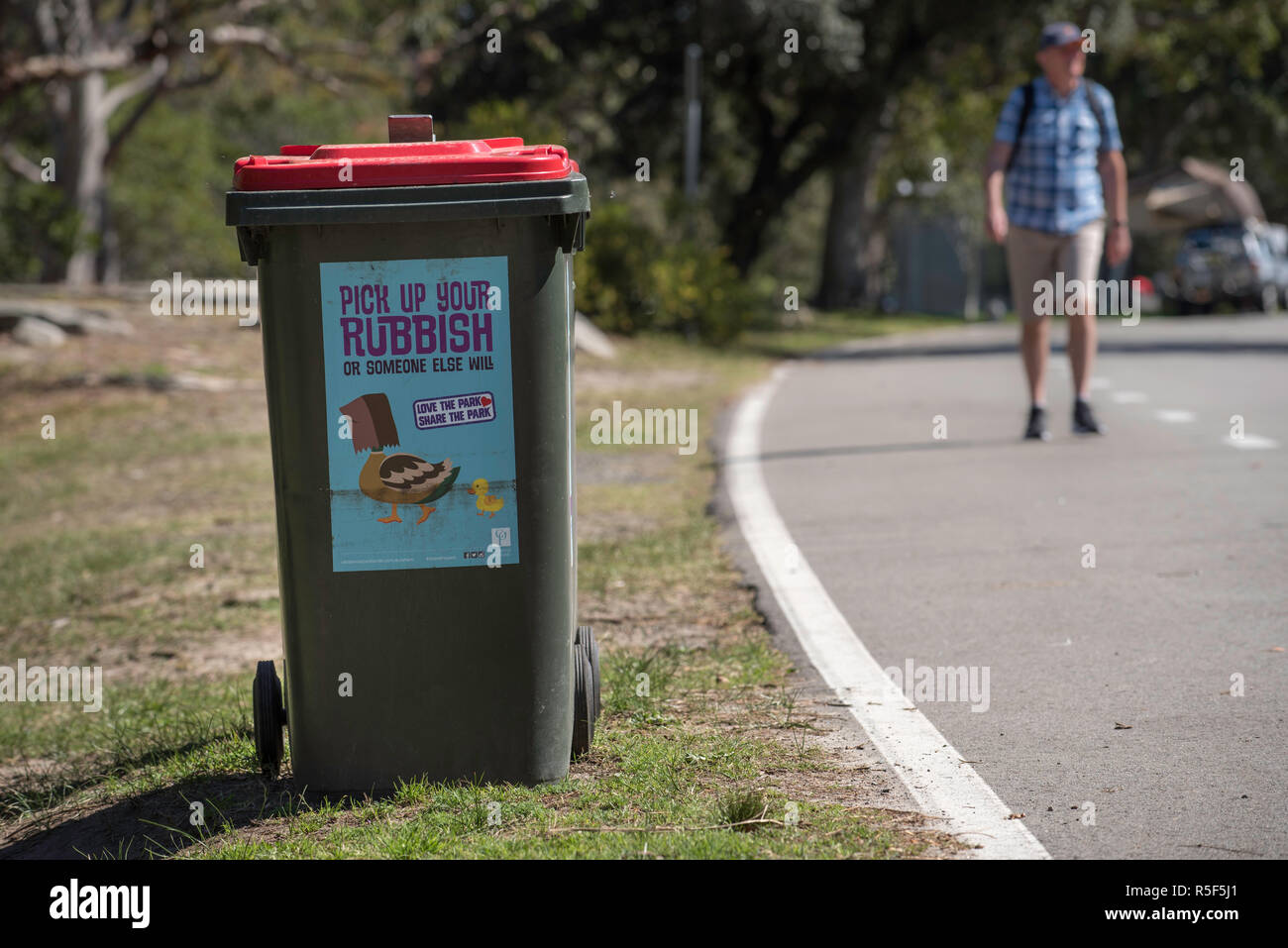 A rubbish (trash) bin in Centennial Park with a humorous decal encouraging people to protect the native animals and not litter Stock Photo