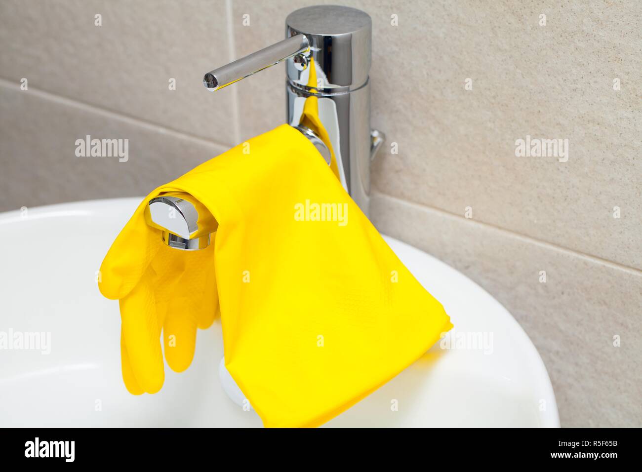 Close up picture of yellow rubber gloves ang brush for cleaning